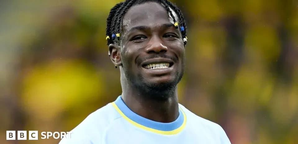 Jugador sonriendo con camiseta azul en el campo