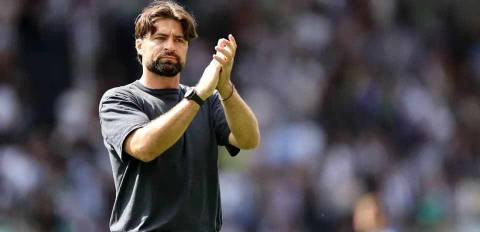 Entrenador aplaudiendo a los aficionados en el estadio