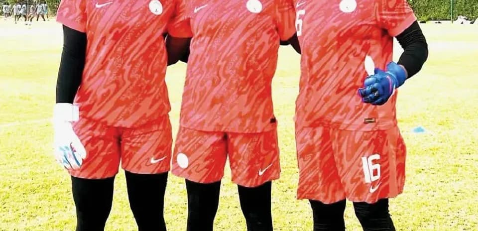 Tres porteras de fútbol posando en uniforme rojo
