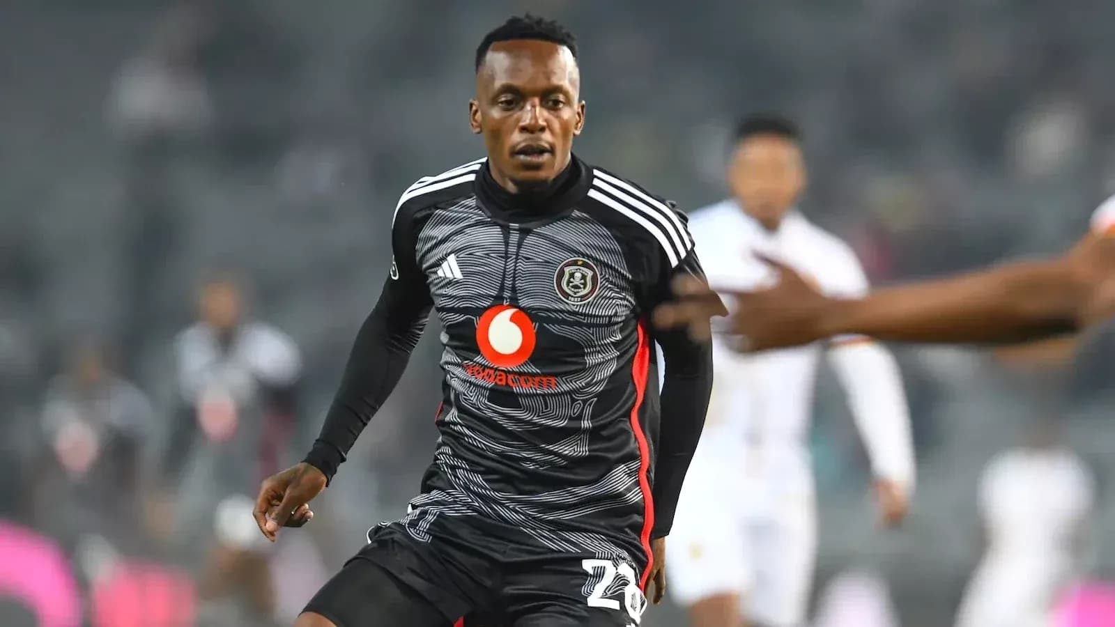 Jugador de fútbol corriendo en uniforme de Orlando Pirates