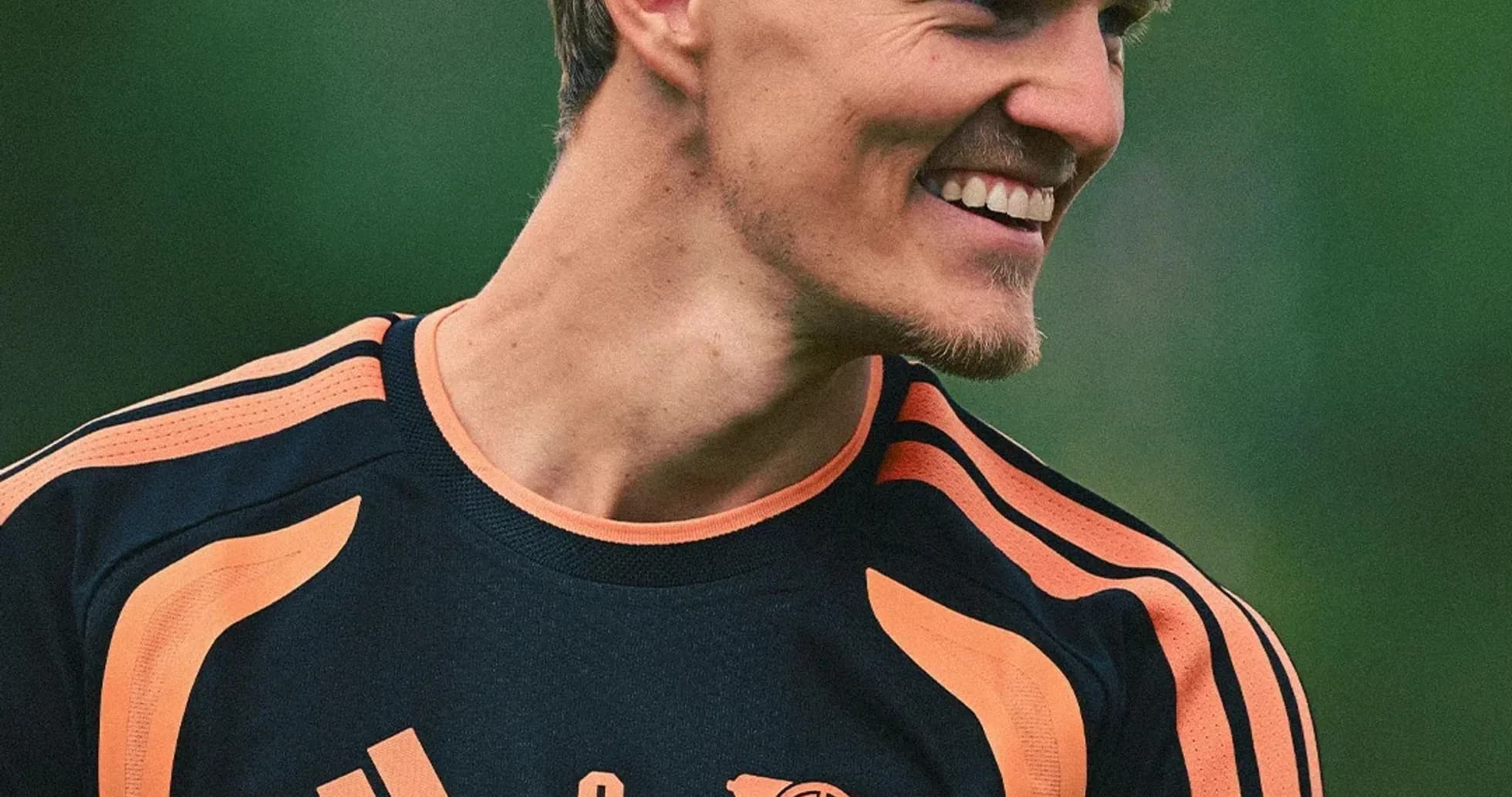 Jugador sonriente en entrenamiento con camiseta de Arsenal