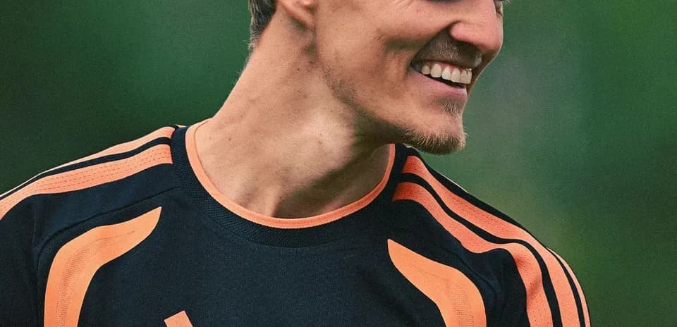 Jugador sonriente en entrenamiento con camiseta de Arsenal