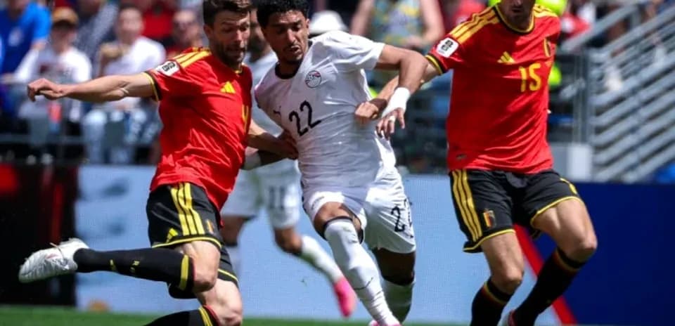 Jugador de Egipto esquivando a dos rivales belgas