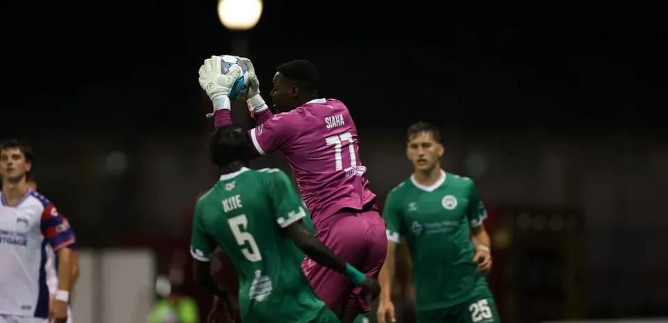 Portero atrapando el balón en el partido