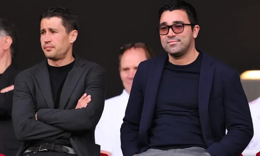 Dos hombres sentados en un palco durante evento deportivo