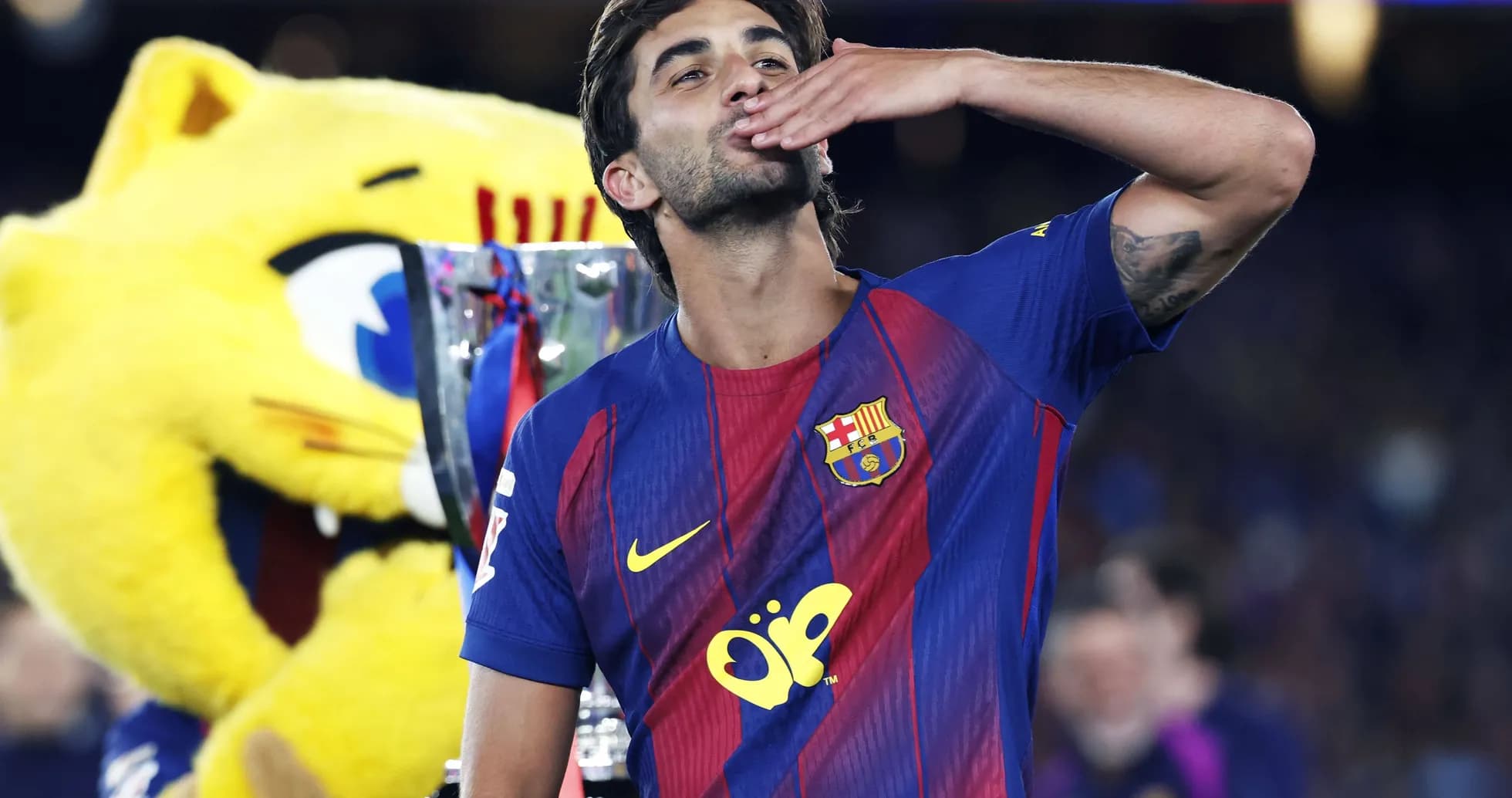 Jugador de Barcelona besando trofeo con mascota