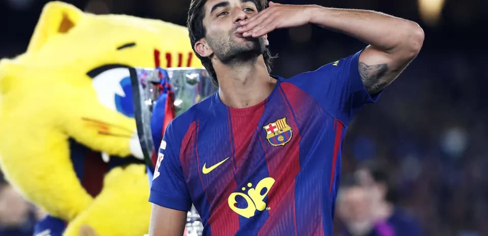Jugador de Barcelona besando trofeo con mascota