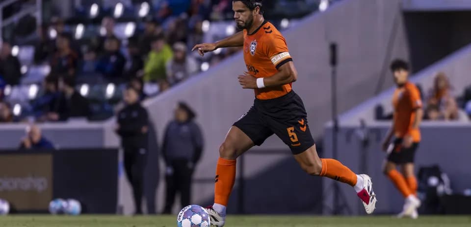 Jugador de Orange County SC corriendo con el balón