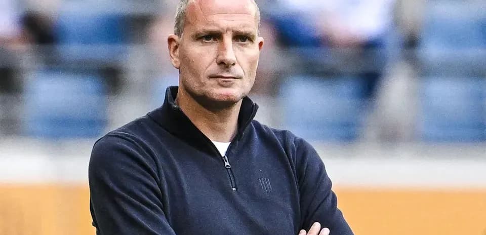 Entrenador observando el partido con los brazos cruzados