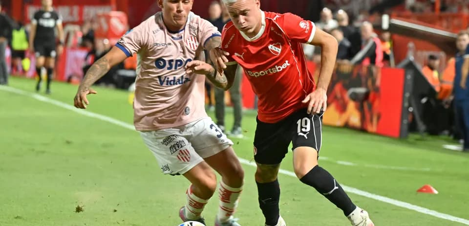 Dos jugadores compitiendo por el balón en el partido