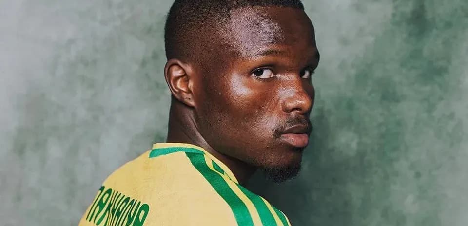 Jugador posando con camiseta amarilla y verde