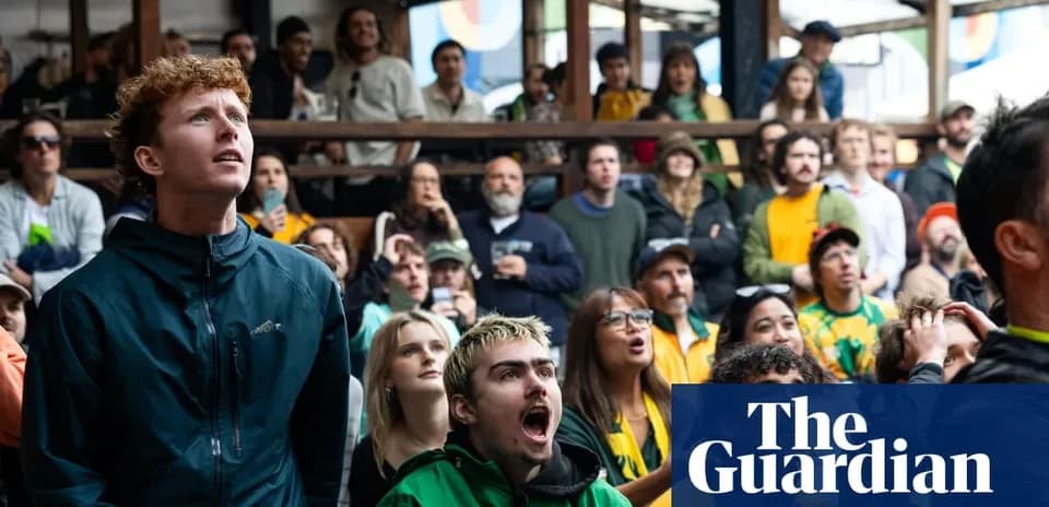 A group of fans watching a sports event indoors