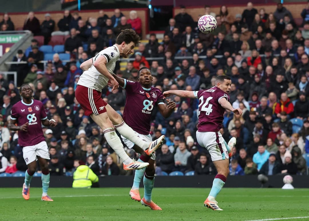 Jugador de Arsenal saltando para cabecear el balón