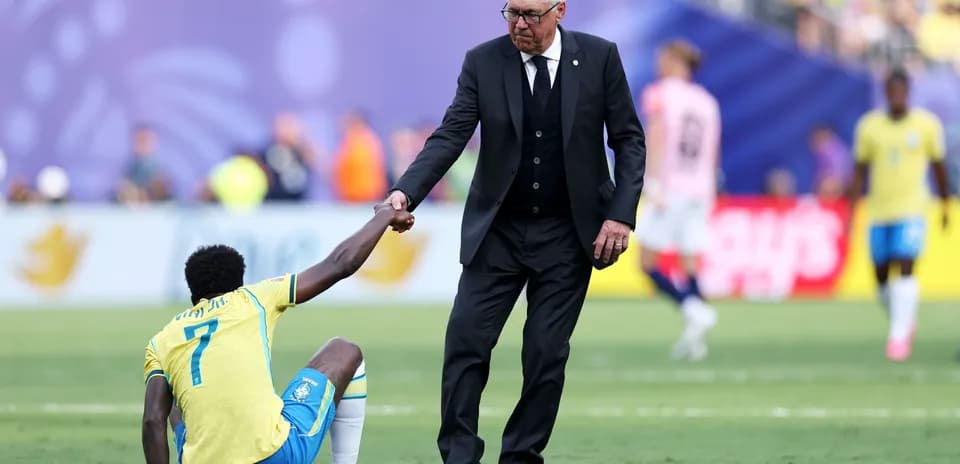 Entrenador ayudando a jugador caído en el campo