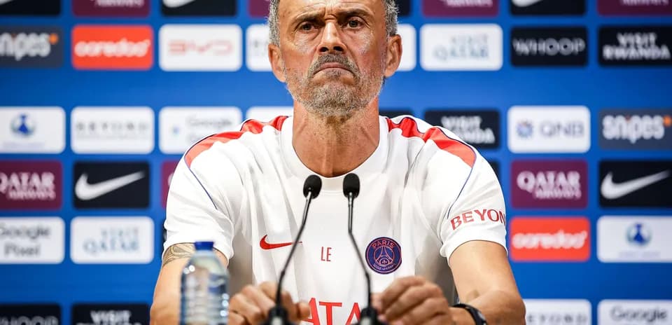 Entrenador en rueda de prensa con micrófonos frente