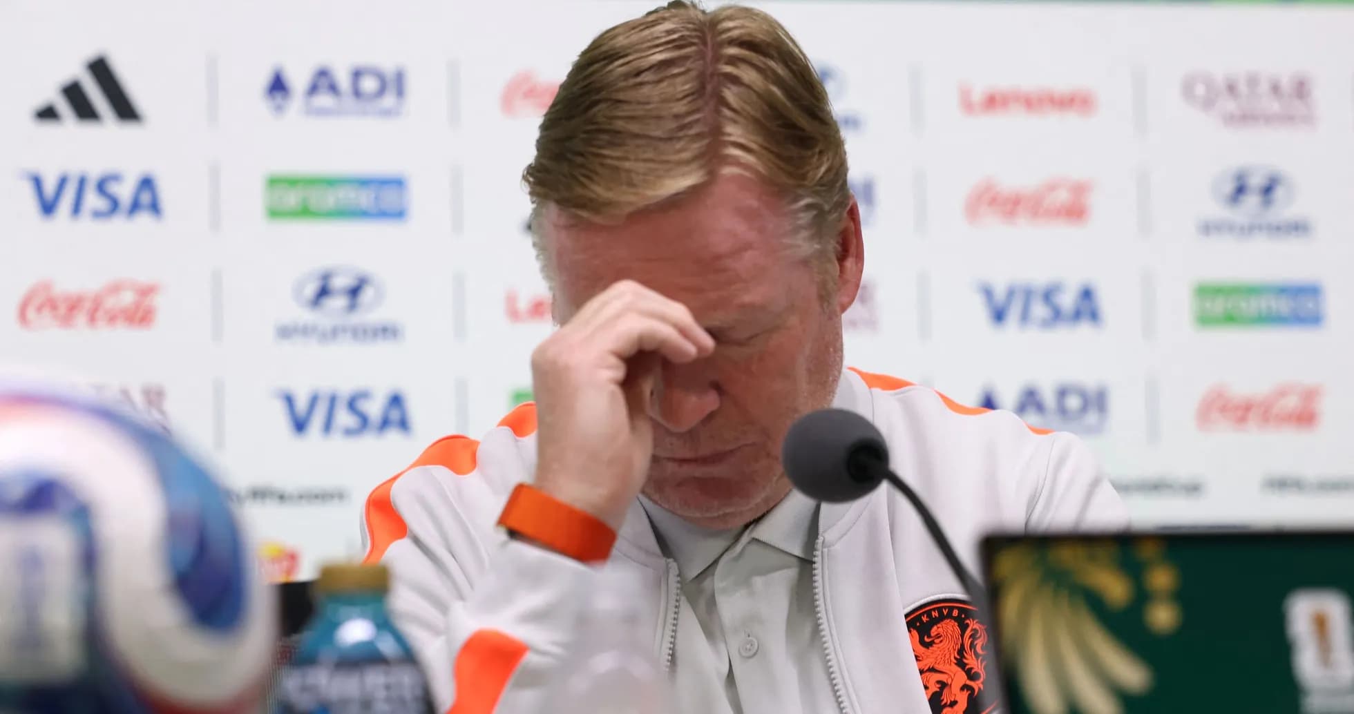 Entrenador con la cabeza agachada en conferencia de prensa