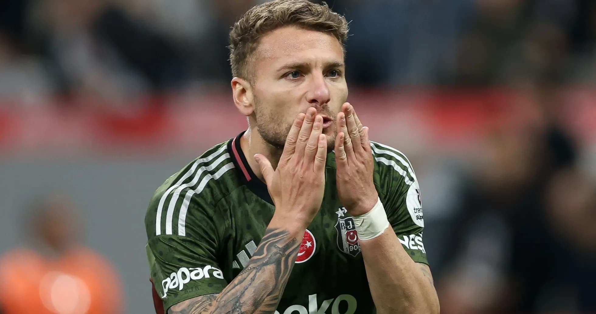 Jugador de Beşiktaş besando sus manos en el campo