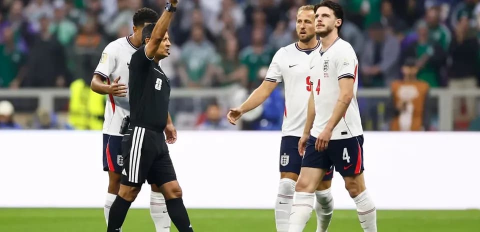 Árbitro mostrando tarjeta amarilla a jugador inglés