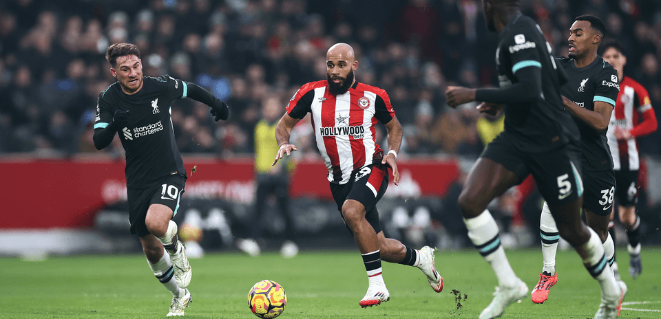 Jugador de Brentford driblando a jugadores de Liverpool