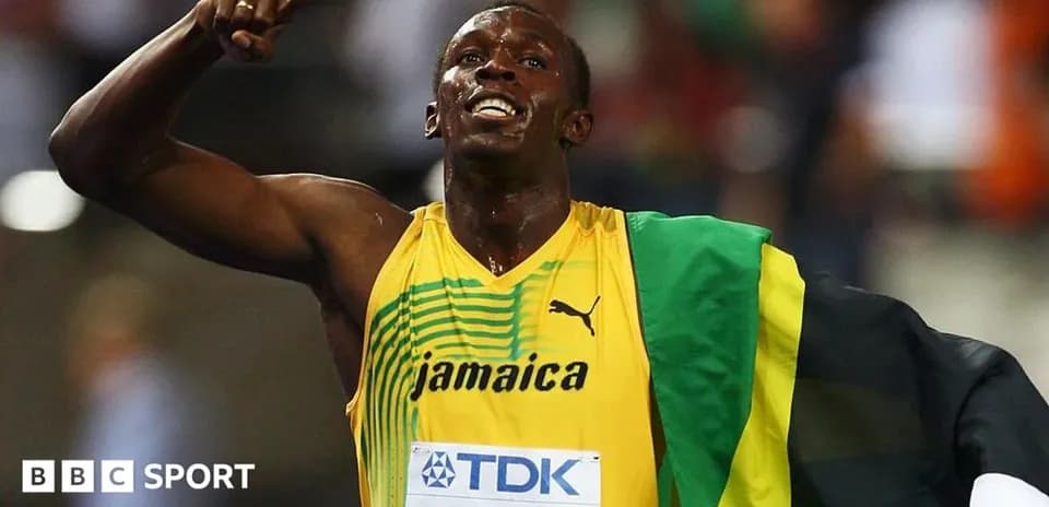 Atleta celebrando con bandera de Jamaica tras carrera