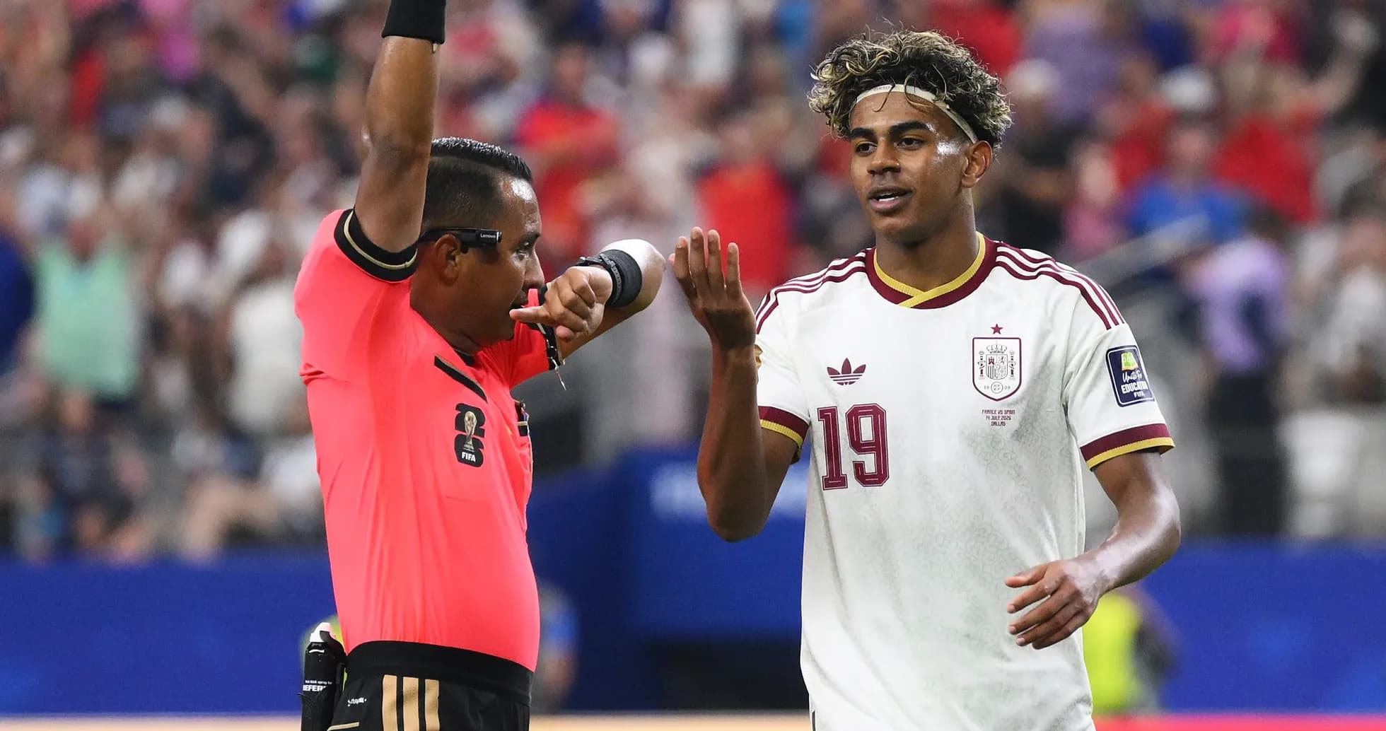 Árbitro mostrando tarjeta mientras jugador discute