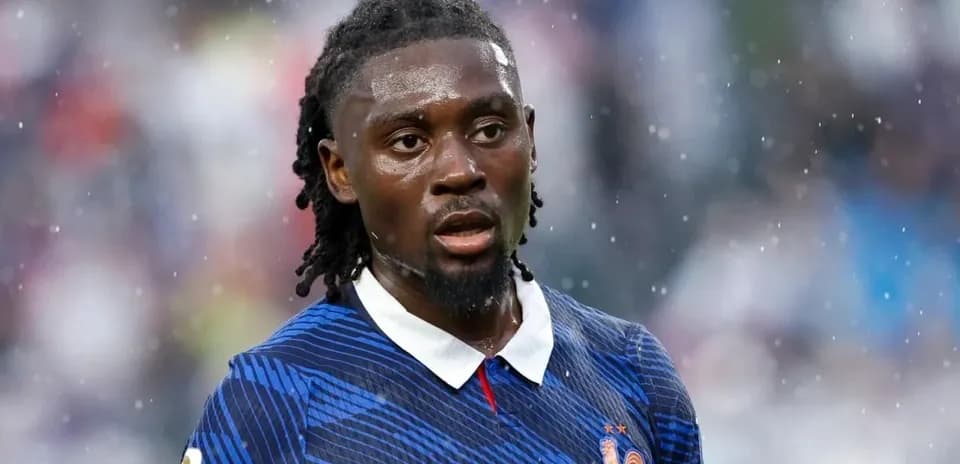 Jugador de fútbol con camiseta de Francia bajo la lluvia