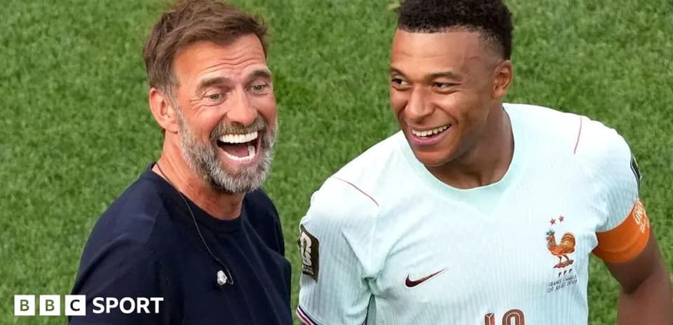 Entrenador y jugador riendo en el campo