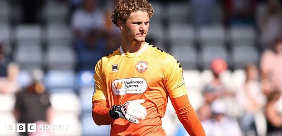 Portero con guantes en uniforme naranja durante partido