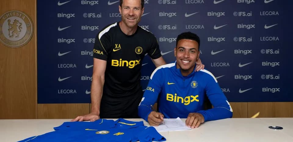 Jugador firmando contrato con entrenador en club Chelsea