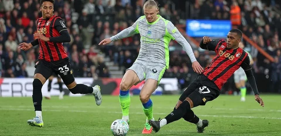 Haaland dribla entre dos defensores de Bournemouth