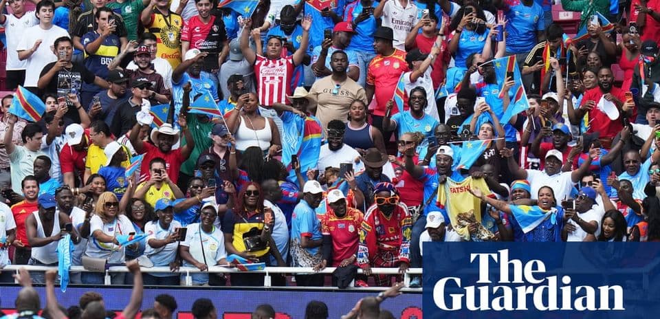 Aficionados con banderas animando en las gradas