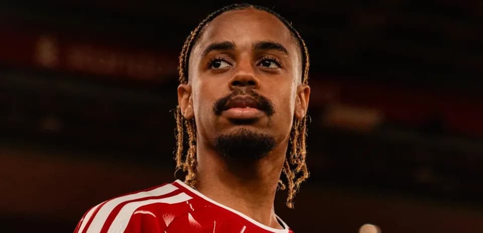 Jugador con camiseta roja mirando hacia la distancia