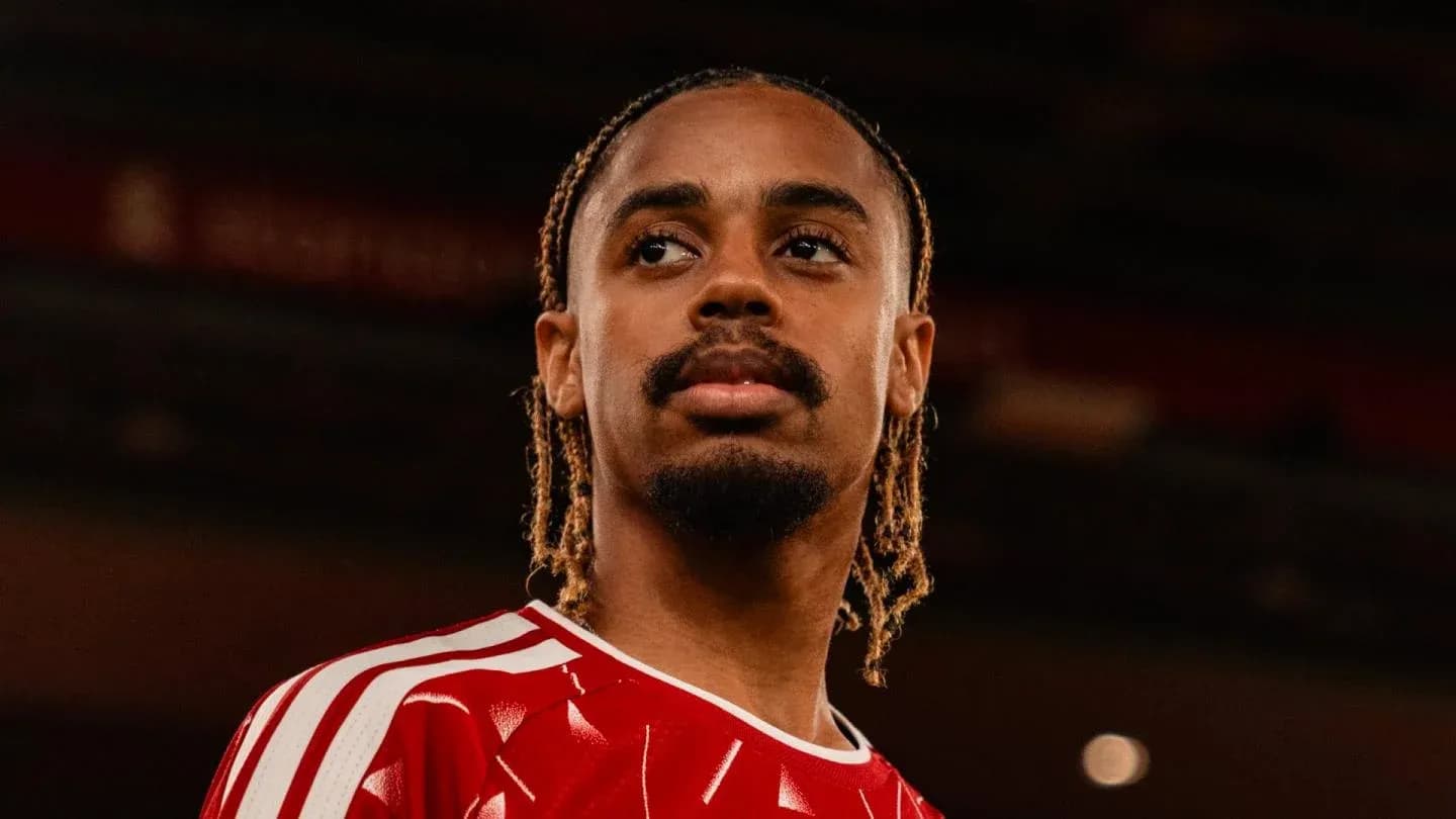 Jugador con camiseta roja mirando hacia la distancia