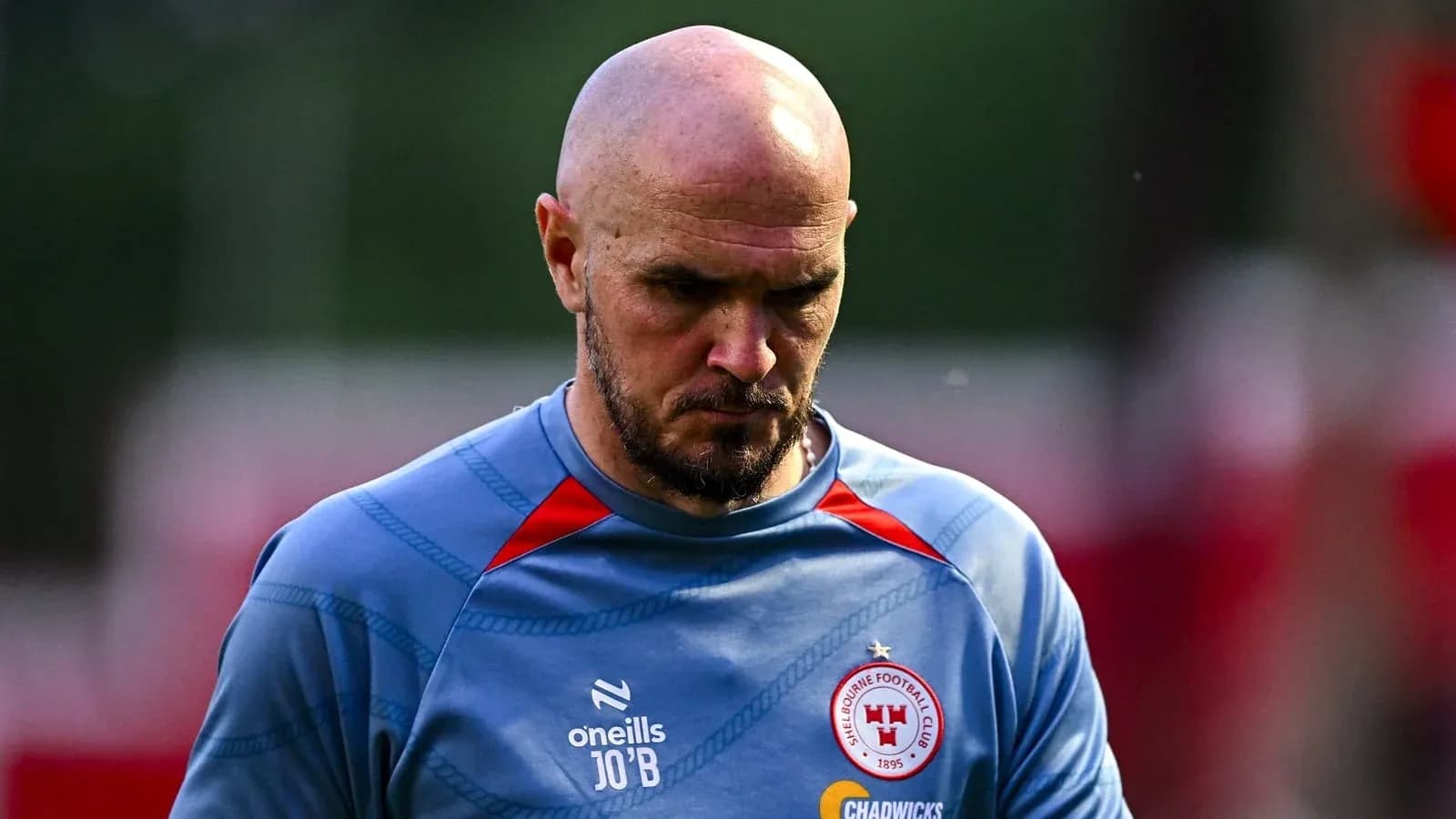 Jugador con camiseta de entrenamiento, mirando hacia abajo