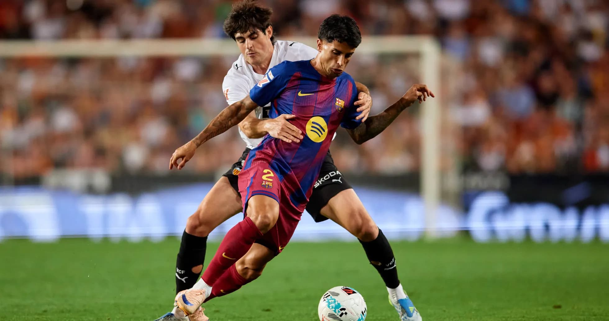 Jugador del Barcelona luchando por el balón contra oponente