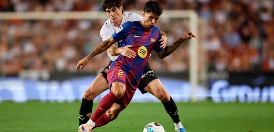 Jugador del Barcelona luchando por el balón contra oponente