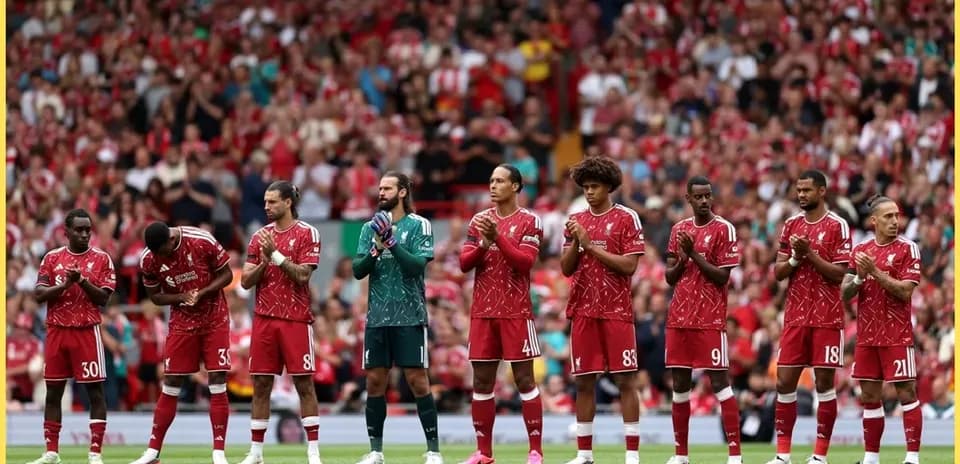 Jugadores de Liverpool alineados en el campo aplaudiendo