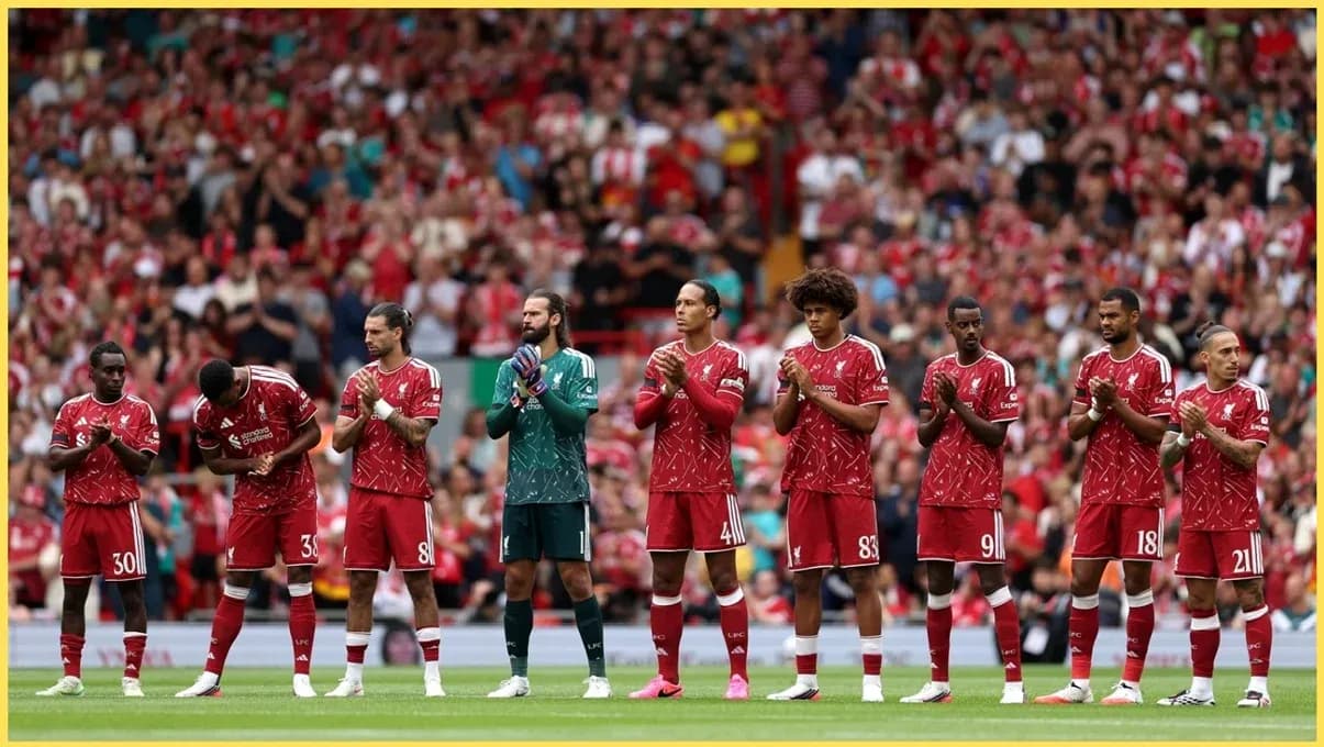 Jugadores de Liverpool alineados en el campo aplaudiendo