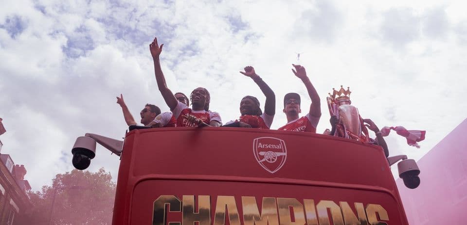 Jugadores de Arsenal celebrando en autobús campeón