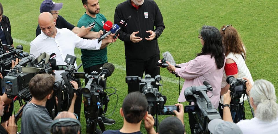 Entrenador respondiendo preguntas de periodistas en campo