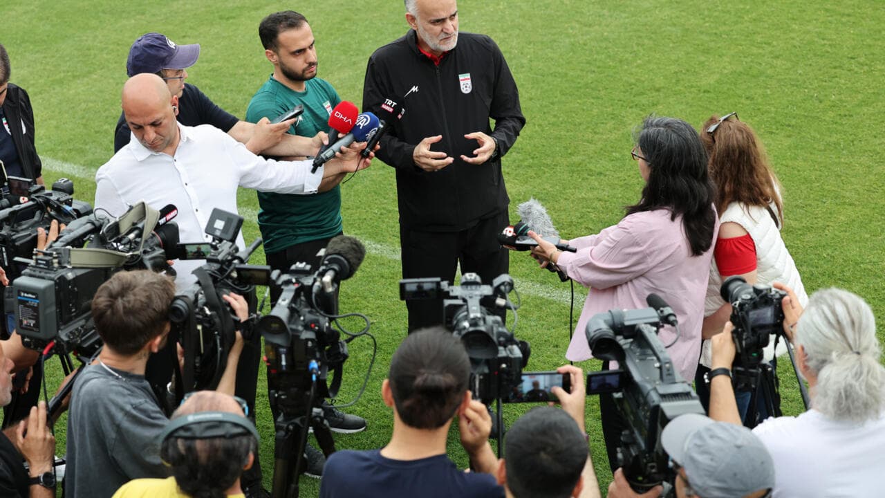 Entrenador respondiendo preguntas de periodistas en campo