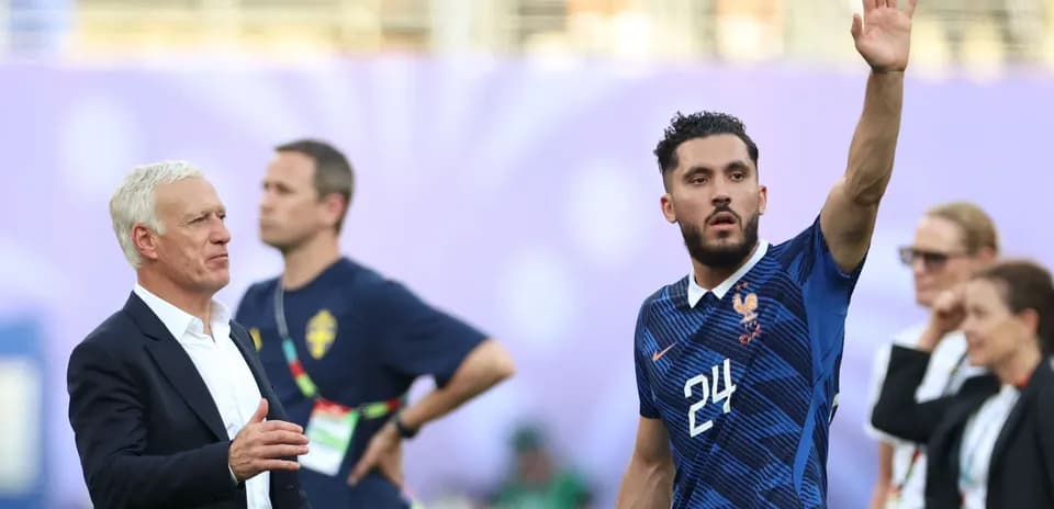 Jugador francés saludando mientras entrenador observa
