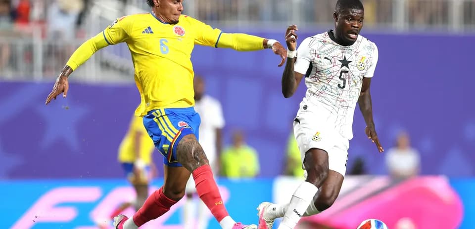 Jugador colombiano intentando quitar el balón a jugador ghanés