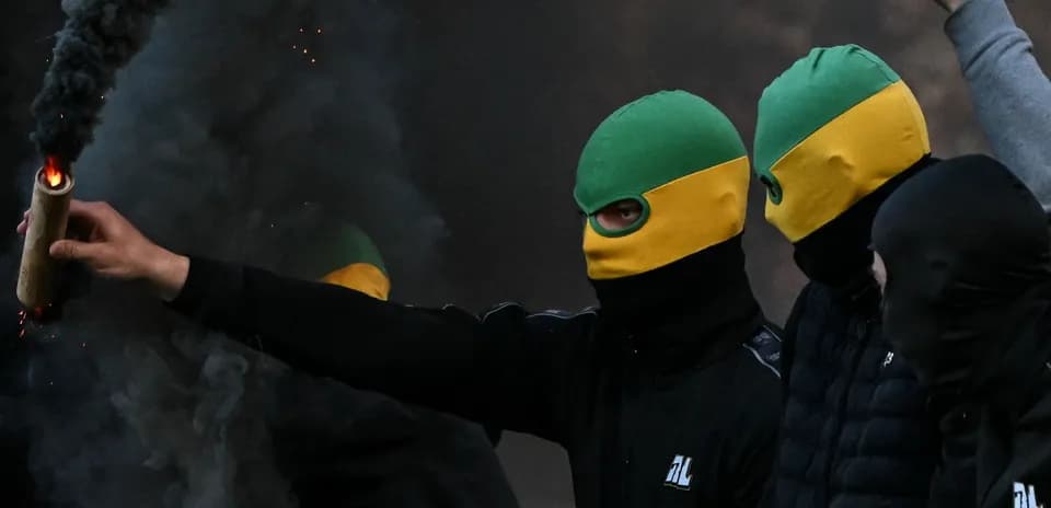 Person con bengala en un ambiente de disturbios