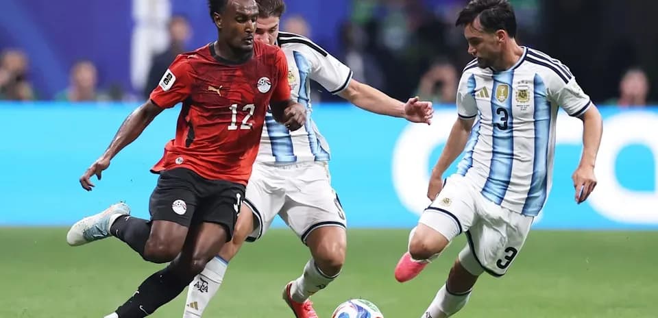 Jugador de Egipto esquivando a dos defensores argentinos