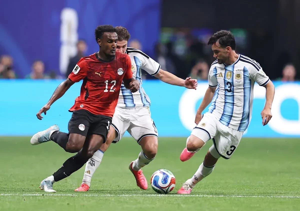 Jugador de Egipto esquivando a dos defensores argentinos