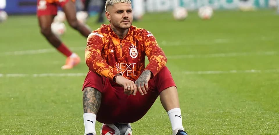 Jugador sentado sobre balón durante calentamiento