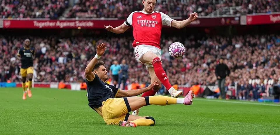 Jugador de Arsenal esquivando a un oponente