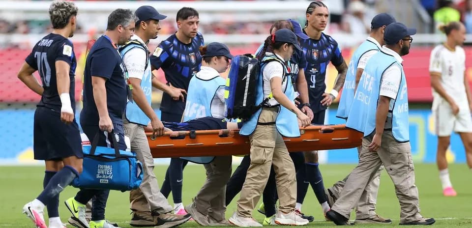 Personal médico transportando a jugador lesionado en camilla