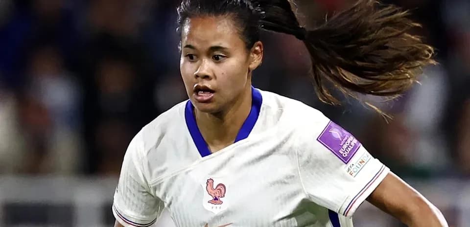 Jugadora de fútbol de Francia corriendo con el balón